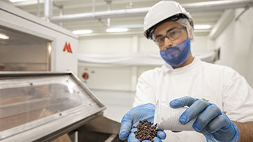 Three people stand above a counter filled with chocolate bars and several toppings, showing the kind of innovative chocolate solutions Cargill and customers pursue together. 