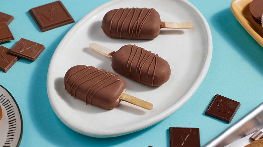 Several chocolate-covered ice cream pops displayed on a white plate, highlighting their rich, dark coating and frozen texture. Several chocolate-covered ice cream pops displayed on a white plate, highlighting their rich, dark coating and frozen texture.