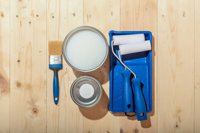 brush and rollers with blue tray on wooden floor