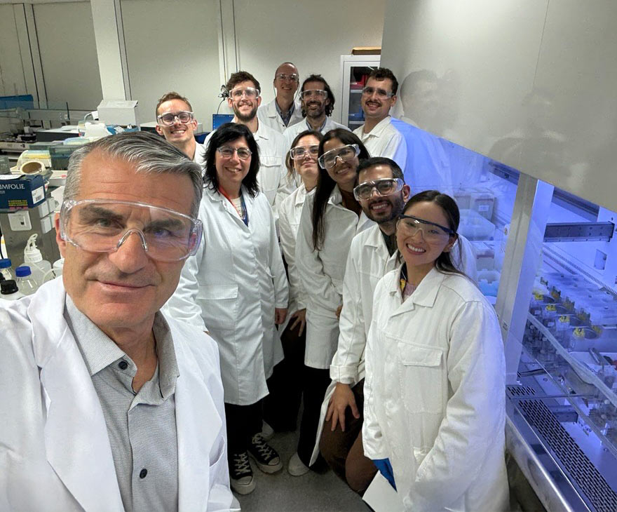 Research and development team wearing laboratory coats and safety glasses in a laboratory.