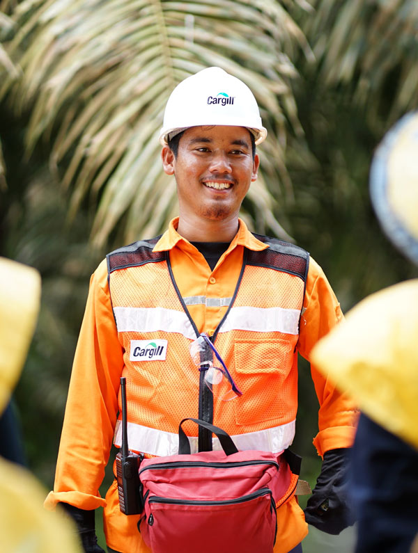 Employee wearing personal protective equipment at a palm plantation. Photo credit: Nuning Muryati, Cargill communications manager.