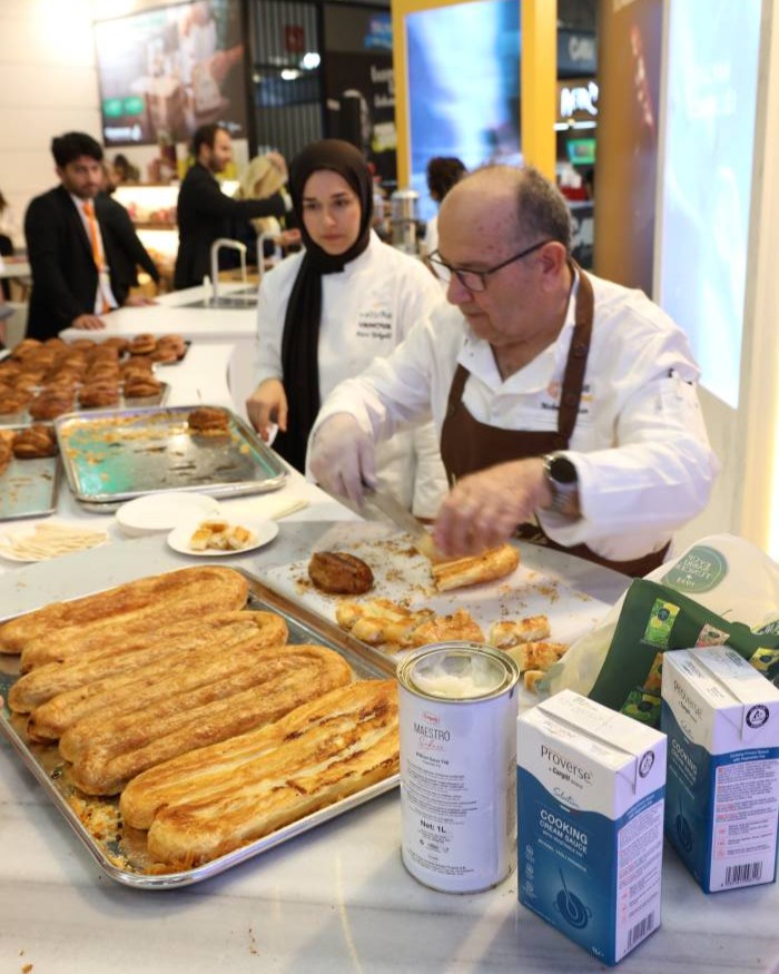 Two chefs preparing and presenting baked goods at the Cargill Gurme trade show booth.